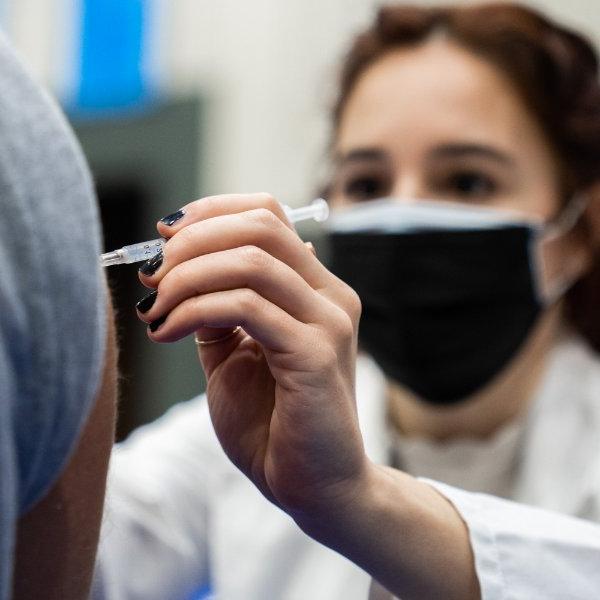 A student in the Physician Assistant Studies program gives a 新型冠状病毒肺炎 vaccination shot.